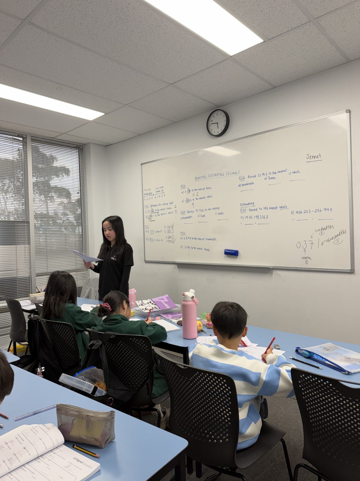 A Signal Education tutor teaching a maths class at the whiteboard